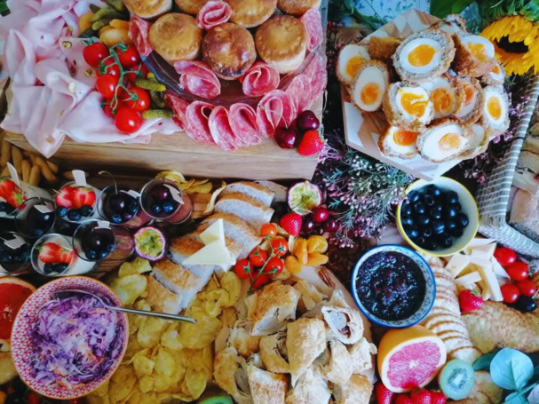 A vibrant assortment of cheeses, meats, pastries, fruits, and spreads on a decorative platter.